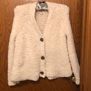 Cream fleece cardigan with brown buttons.